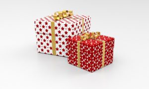 Two presents. One is bigger and wrapped in white paper with red stars on it and has a yellow ribbon. The smaller one is wrapped in red paper with white fir trees on it and has a yellow ribbon. 