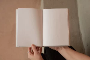 Photo of the hands of a white person holding open a book that is, curiously enough, completely blank on the inside! 