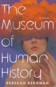 Book cover for The Museum of Human History by Rebekah Bergman. The image on the cover is a painting of a white woman whose right shoulder is hunched over slightly. She’s touching the bottom of her face as if she’s contemplating something. She does not appear to be wearing a shirt, although we can only see the skin of her arm, shoulder, hand, and neck. Her head is covered from the bridge of her nose up by a pink, yellow, orange, and blue cloud that grows lighter the further up it you look. 