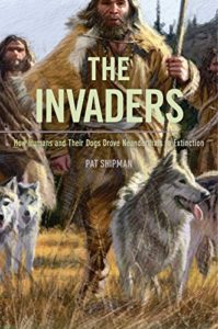 Book cover for The Invaders: How Humans and Their Dogs Drove Neanderthals to Extinction by Pat Shipman. Image o cover shows two people walking on a grassy plane next to two wolf dogs. The people are carrying wooden spears, dressed in heavy animal fur cloaks, and have long, shaggy brown hair and pale skin. 