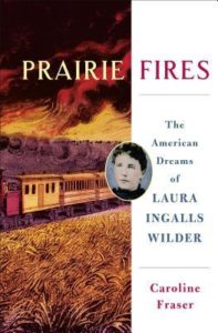 Book cover for Prairie Fires: The American Dreams of Laura Ingalls Wilder by Caroline Fraser. Image on cover is a painting of a dingy white 1800s train travelling down a lonely stretch of train tracks on the prairie as a large fire burns in the background. 