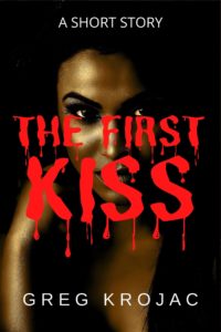 Book cover for The First Kiss by Greg Krojac. Image on cover shows a closeup photograph of a black woman who is staring seriously at the audience with the tiniest smile on her lips. Her skin in glowing near a small light in an otherwise dark room. 