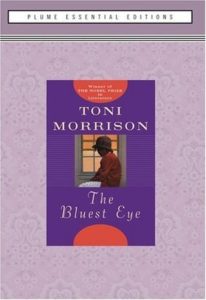 Book cover for The Bluest Eye by Toni Morrison. Image on cover shows a painting of a young black girl sitting next to a window with her face half turned out to see the street. She is wearing an old-fashioned red sweater and a small hat. 