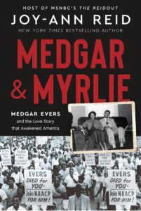 Book cover for Medgar and Myrlie: Medgar Evers and the Love Story That Awakened America by Joy-Ann Reid. Image on the cover shows a newspaper photo of Medgar and Myrlie Evers marching in a civil rights parade. Above it is a black and white snapshot of this couple sitting comfortably on a couch together in a living room. She’s wearing and dress and he’s wearing a suit. His arm is around her as he glances at her with a loving expression on his face. 