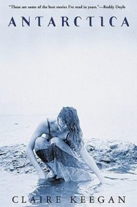 Book cover for Antarctica by Claire Keegan. Image on cover shows a photograph a white woman with long, wavy hair wearing a light summer dress with spaghetti straps on it. She’s crouching down and touching the water below her gently. There is a blue filter on this photo that makes everything look cold and possibly even icy. 