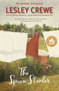 Book cover for The Spoon Stealer by Lesley Crewe. Image on cover shows a red sleeveless dress and two white sheets hanging to dry on an outdoor clothesline. There is a wicker clothes basket partially hidden by the dress and sheets, but with the wind blowing everything around we get a glimpse of it. The grass below is growing tall, and there is a thick forest behind this scene. 