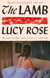 Book cover for The Lamb  by Lucy Rose. Image on cover shows a painting of a white woman sitting on a bed with her back facing the audience. She’s topless and has wrapped her lower half in a blue comforter as she waits for who knows what. There is a slight slump in her shoulders that makes me afraid for what might happen next. 