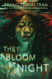 Book cover for They Bloom at Night by Trang Thanh Tran. Image on cover shows a realistic drawing of a young Asian woman with long black hair submerged in water and staring at the audience with a frightened expression on her face. 