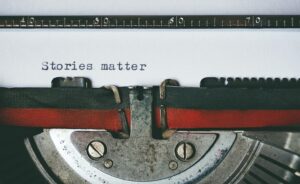 The words “stories matter” have been typed out on an old-fashioned manual typewriter. 