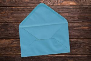 A blue envelope lying with its flap up. It’s ready to receive the card or letter that will go on there. 
