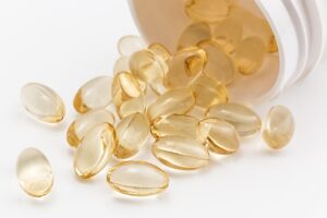 Closeup photo of small pills that look like vitamin e vitamin pills to me. They are soft, small, oblong, and slightly yellow. 