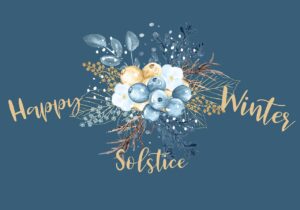 The text of this image has a dark blue background and the phrase “happy winter solstice” written in a cursive yellow font. In the centre of the image, a sprig of golden and blue berries is covered in snow and includes some dead twigs that are still attached to the recenlty living portions of this plant. 