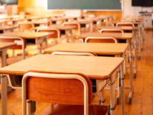 Empty rows of desks in a high school classroom. 