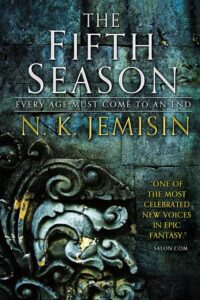 Book cover for The Fifth Season (The Broken Earth, #1) by N.K. Jemisin. Image on cover shows what appears to be a very old door that is partially covered by grime. On the door an ornate metal object has been forged that curls into itself as if it has leaves or perhaps small tentacles. It’s beautiful. 