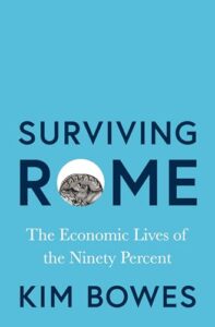 Book cover for Surviving Rome: The Economic Lives of the Ninety Percent by Kim Bowes. Image on cover shows a close-up photo of a silver Roman coin. The face on the coin is pointing up, and you can only see the top half of the coin.