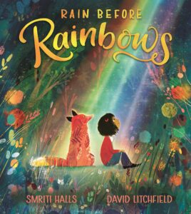 Book cover for Rain Before Rainbows by Smriti Prasadam-Halls. Image on cover is a cute drawling of a young girl sitting next to a red fox in the forest while they both look up at a rainbow that is beaming down at them. 