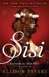 Book cover for Sisi: Empress on Her Own by Allison Pataki. Image on cover shows a young brunette white woman who is facing away from the audience. There are little white flower tucked in the French brain of her hair.