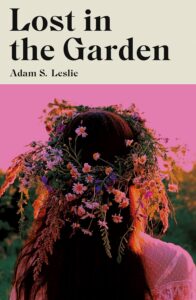 Book cover for Lost in the Garden by Adam S. Leslie. Image on cover shows a grainy photo of a young white woman with wavy light brown hair walking away from the viewer. She has dozens of small pink and white flowers stuck in her hair haphazardly. 