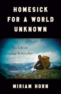 Book cover for Homesick for a World Unknown: The Life of George B. Schaller by Miriam Horn. Image on cover shows a photo taken of a white male 1950s scientist named George who is wearing a very large backpack and sitting on a rock as he surveys the valleys and mountains ahead of him.