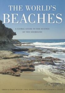 Book cover for The World's Beaches: A Global Guide to the Science of the Shoreline by Orrin H. Pilkey. Image on cover shows a photo of a beach covered in large, flat rocks and some sand. Waves are gently lapping against the rocks and beach.