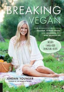 Book cover for Breaking Vegan: One Woman's Journey from Veganism, Extreme Dieting, and Orthorexia to a More Balanced Life by Jordan Younger. Image on cover shows the author, a young, thin, pretty white woman, sitting on a picnic blanket outside in a park. There’s a bag filled with produce next to her and a forest behind her.